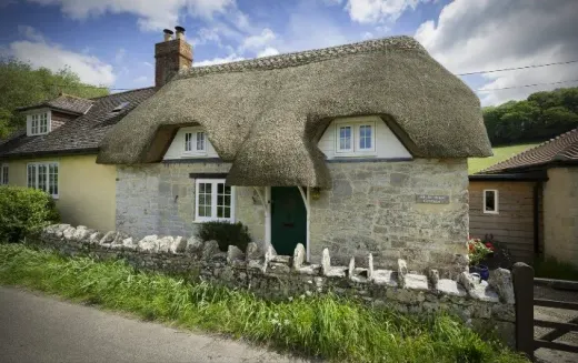 Thatched cottage with white heritage-style windows